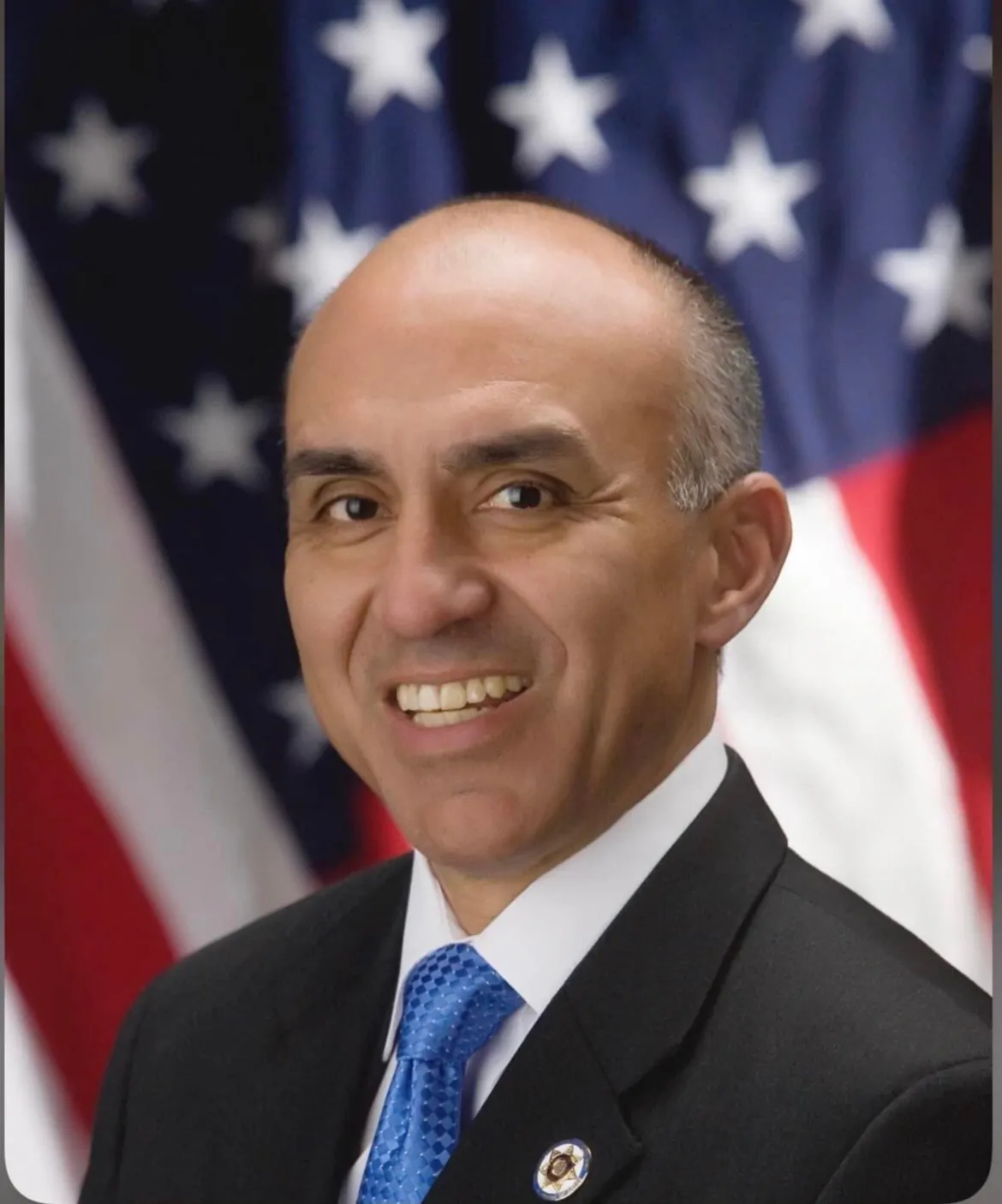 Michael Ramos, former District Attorney of San Bernardino County, in front of the United States flag